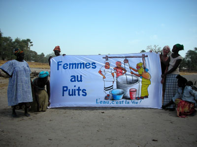 Village women in their garden with our banner, Women at the Well, Water is Life 